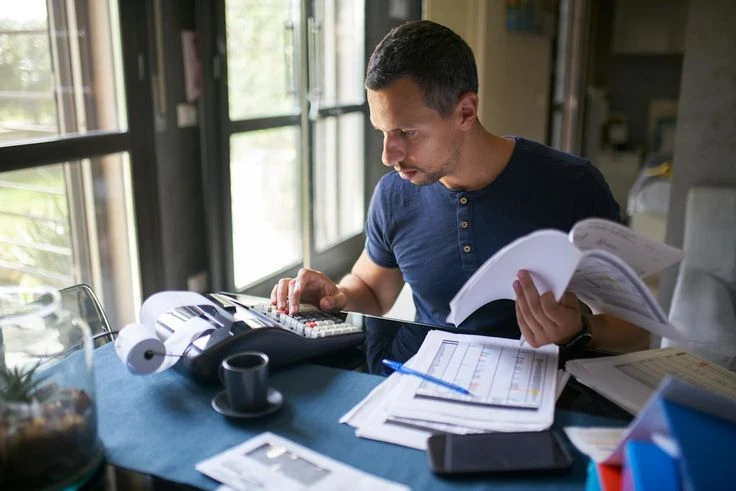 a homeowner reviewing insurance documents with a calculator

