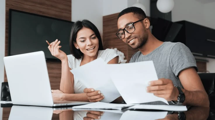 The Top 5 Financial Moves You Should Make Before July Couple planning their financial moves as they review documents.