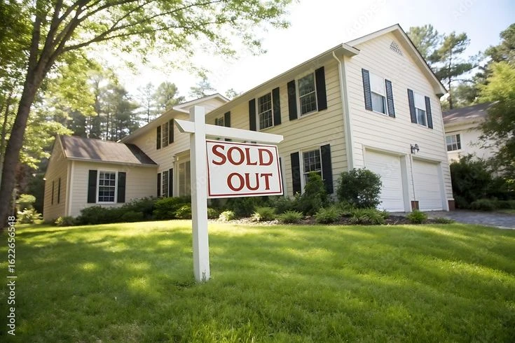 Suburban Home With Sold Out Sign on a Sunny Day
