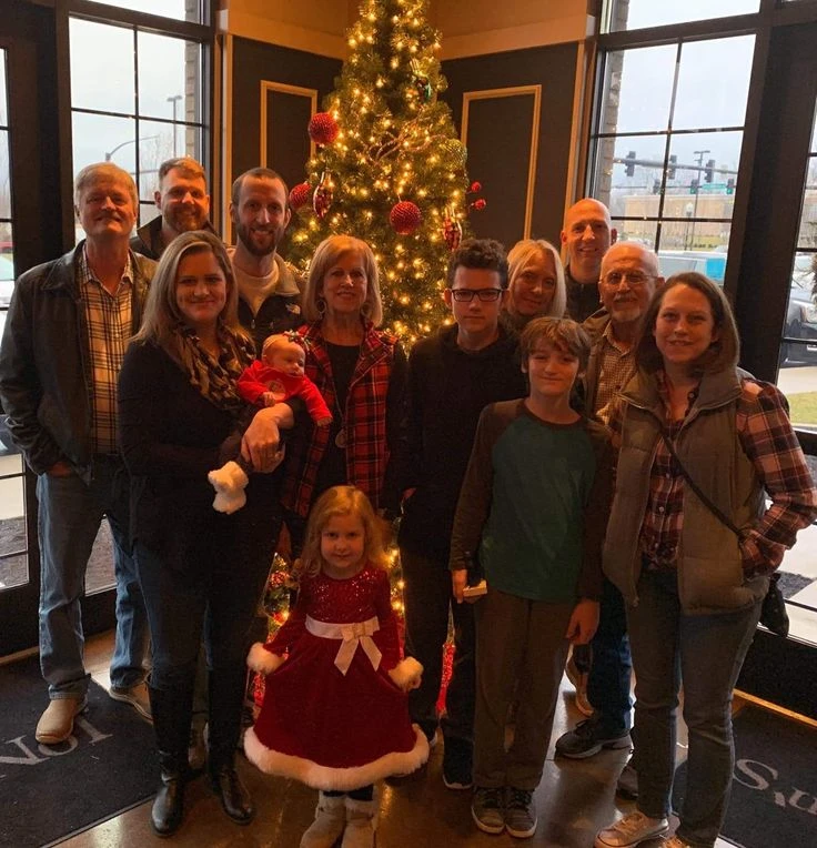 The Best Christmas Gifts a Parent Can Give in 2026 A multigenerational family near a softly lit Christmas tree