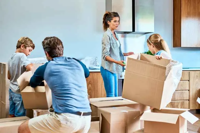 Why Fall Home Buyers Are the Most Underinsured Group Family unpacking boxes in a new home after closing